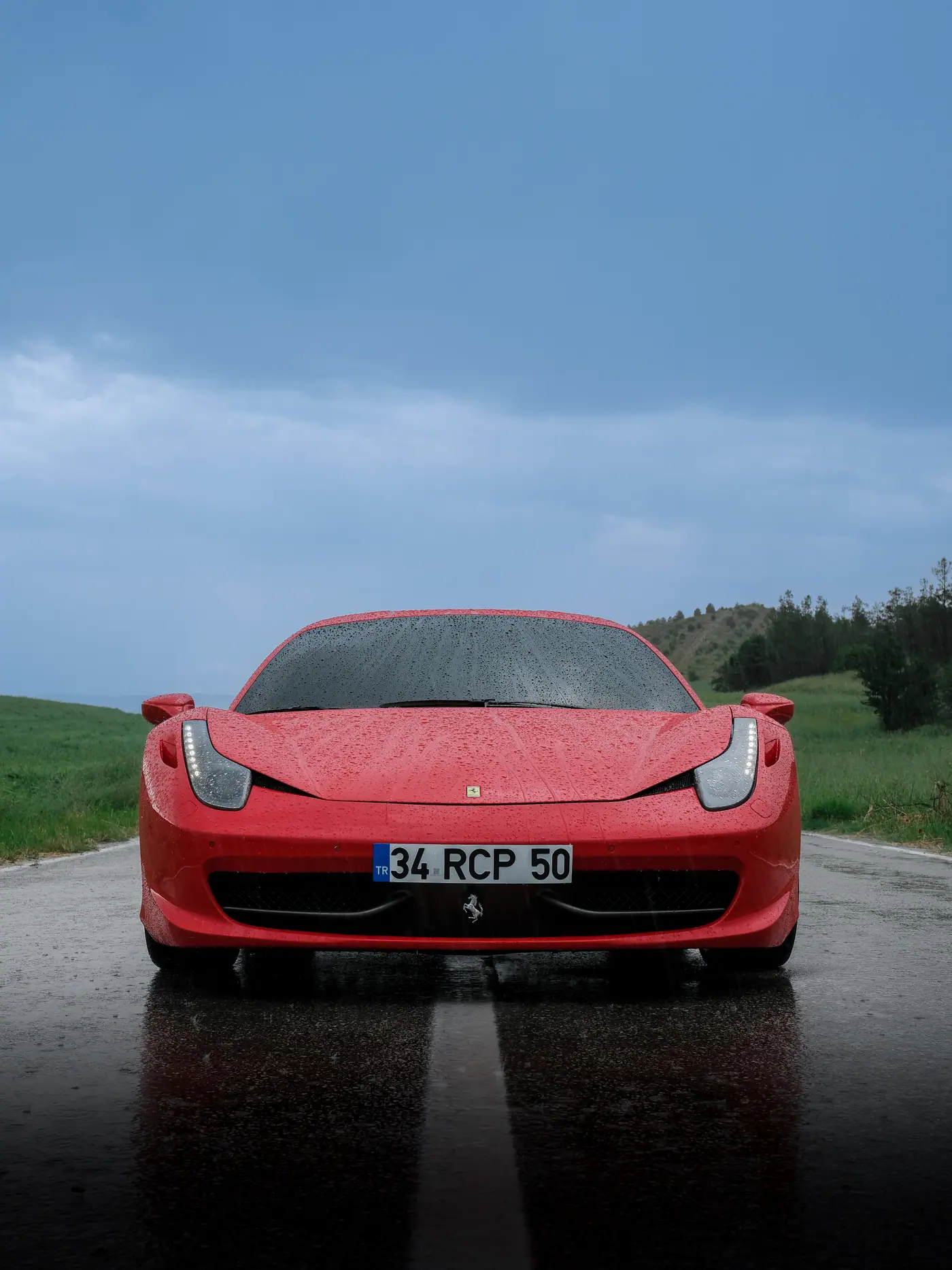 Ara Motors kırmızı Ferrari için yağmurda ön cephe otomotiv fotoğrafı